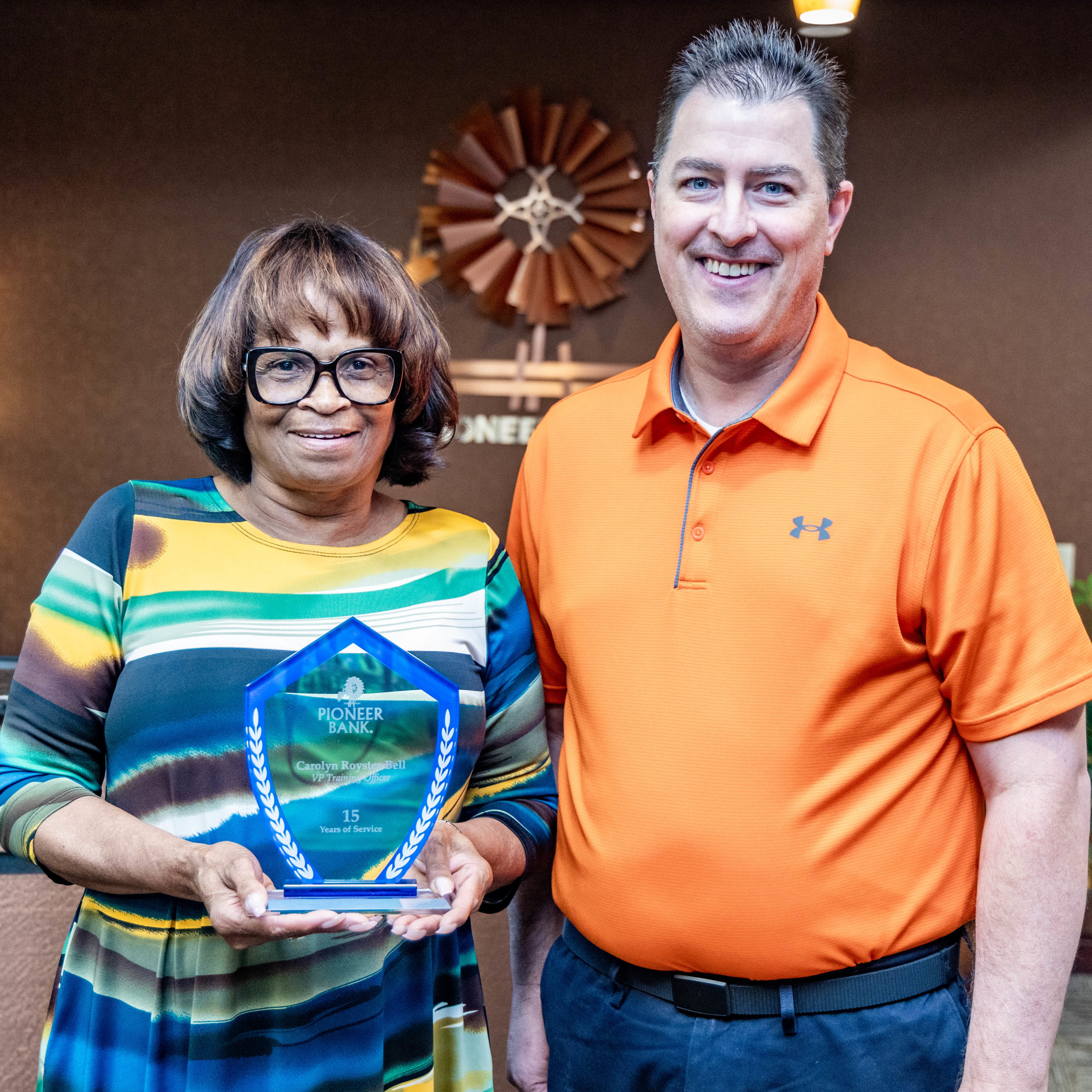 Carolyn Bell, Vice President Training Officer/Retail Banking, receives her plaque from Christopher Palmer, CEO/President of Pioneer Bank